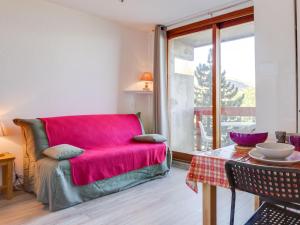 a living room with a red couch and a table at Apartment Soyouz Vanguard-82 by Interhome in Le Corbier +28 photos