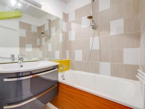 a bathroom with a sink and a bath tub at Apartment Soyouz Vanguard-82 by Interhome in Le Corbier