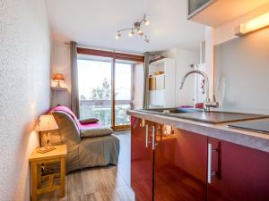 a kitchen with a sink and a couch in a room at Apartment Soyouz Vanguard-82 by Interhome in Le Corbier
