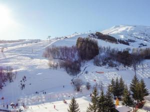 a group of people skiing down a snow covered slope at Studio Pegase Phenix-68 by Interhome in Le Corbier