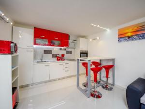 una cocina con armarios rojos y taburetes rojos en Holiday Home Lana 1 by Interhome, en Matulji