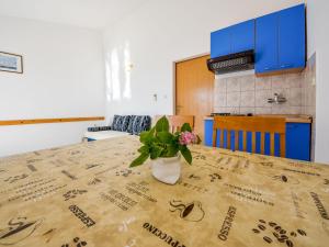 a table with a vase of flowers on top of it at Apartment Vukić-1 by Interhome in Tribanj-Krušćica
