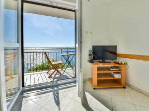 a room with a television and a balcony with a view at Apartment Vukić-1 by Interhome in Tribanj-Krušćica