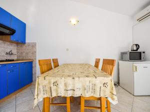 a kitchen with a table with chairs and a refrigerator at Apartment Vukić-1 by Interhome in Tribanj-Krušćica