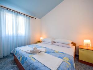 a bedroom with two beds and two lamps and a window at Apartment Vukić-1 by Interhome in Tribanj-Krušćica