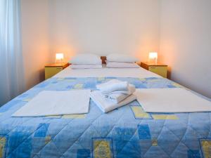 a bedroom with a bed with towels on it at Apartment Vukić-1 by Interhome in Tribanj-Krušćica +14 photos