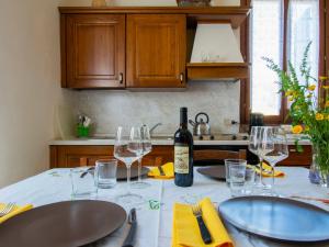 a kitchen with a table with glasses and a bottle of wine at Apartment Cimabue by Interhome in Toiano