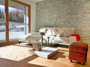 ein Wohnzimmer mit einem Sofa und einem Glastisch in der Unterkunft Apartment Rosablanche E 108 by Interhome in Siviez