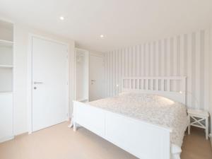 - une chambre blanche avec un lit et un placard dans l'établissement Apartment Littoral by Interhome, au Coq