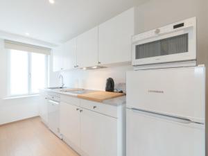 - une cuisine blanche avec des placards blancs et un four micro-ondes dans l'établissement Apartment Littoral by Interhome, au Coq