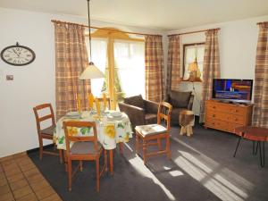 a living room with a table and chairs and a television at Apartment Wohnung 4 - Am Sonneneck by Interhome in Ruhpolding