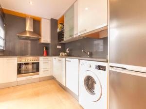 a kitchen with white cabinets and a washer and dryer at Apartment Goleta-1 by Interhome in Cambrils