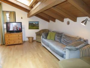 a living room with a couch and a flat screen tv at Apartment Wohnung 8 - Am Sonneneck by Interhome in Ruhpolding