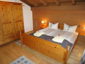 a bedroom with a large wooden bed with two towels at Apartment Wohnung 8 - Am Sonneneck by Interhome in Ruhpolding