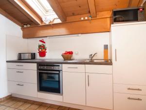 a kitchen with white cabinets and a sink at Apartment Wohnung 8 - Am Sonneneck by Interhome in Ruhpolding