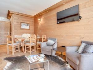 a living room with a table and a television on a wall at Apartment Le Prariond - Val Claret-10 by Interhome in Tignes +13 photos