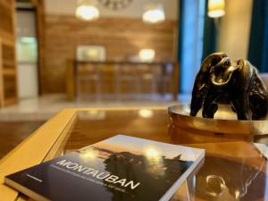 un libro e una statua di elefante di bronzo su un tavolo di L'Ecrin de la Resistance a Montauban