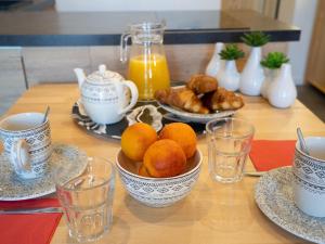a table with a bowl of oranges and cups of orange juice at Studio Le Curling B - Val Claret-39 by Interhome in Tignes