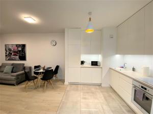 a kitchen and living room with a couch and a table at EXCLUSIVE 2BR! Apartment in CENTER +NETFLIX +GYM in Warsaw