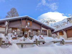 a house covered in snow with a fence at Apartment Le Plan des Reines by Interhome in Chamonix-Mont-Blanc