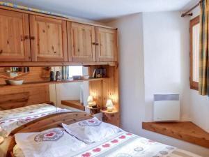 1 dormitorio con 1 cama y armarios de madera en Apartment Le Plan des Reines by Interhome en Chamonix-Mont-Blanc