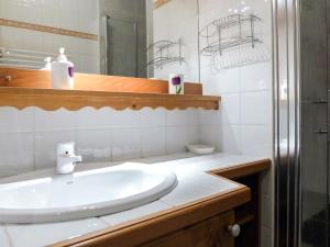 a white bathroom with a sink and a mirror at Apartment Le Plan des Reines by Interhome in Chamonix