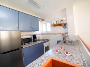 una cocina con armarios azules y fruta en una encimera en Apartment Atlántico-2 by Interhome, en Calpe