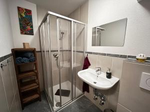 a bathroom with a shower and a sink at Fankhauser OutdoorSport in Haiming