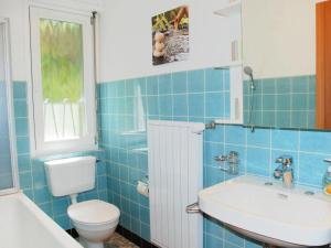 a blue tiled bathroom with a toilet and a sink at Apartment Casablanca OG by Interhome in San Nazzaro +41 photos