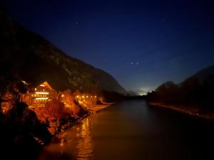 a house on the side of a river at night at Fankhauser OutdoorSport in Haiming