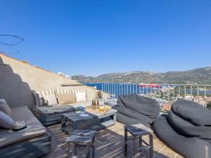 a patio with couches and chairs on a balcony at Apartment La Porte Génoise by Interhome in Porto-Vecchio