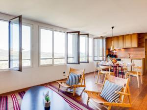 un soggiorno con tavolo, sedie e finestre di Apartment La Porte Génoise by Interhome a Porto Vecchio