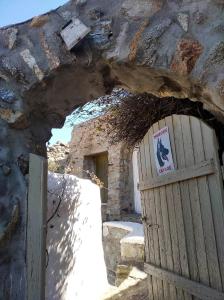 - une entrée pour un bâtiment en pierre avec une porte en bois dans l'établissement Artemis Studio Pyrgi, à Mykonos