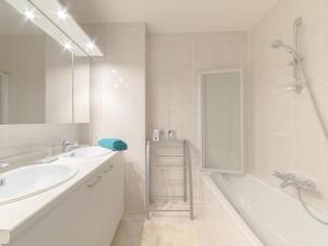 La salle de bains est pourvue d'un lavabo, d'une baignoire et d'une douche. dans l'établissement Apartment Residentie Duinenbries-2 by Interhome, à Bredene