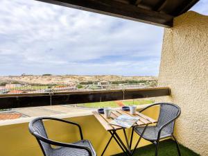 uma mesa e cadeiras numa varanda com vista para o deserto em Apartment Trinquart-6 by Interhome em Seignosse