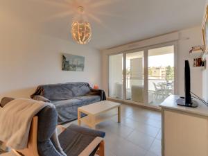 a living room with a couch and a tv at Apartment 79 Bay-2 by Interhome in Cavalaire-sur-Mer