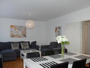 sala de estar con sofá y mesa con flores. en Apartment Michèle - Utoring-20 by Interhome, en Ascona