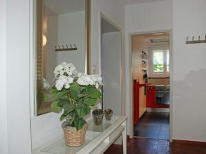 un jarrón con flores blancas sobre una mesa de cristal en un pasillo en Apartment Michèle - Utoring-20 by Interhome, en Ascona