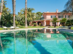 ein Haus mit Palmen und einem Pool in der Unterkunft Villa Giulia by Interhome in La Massimina-Casal Lumbroso