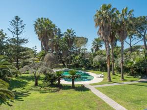 einen Garten mit einem Pool und Palmen in der Unterkunft Villa Giulia by Interhome in La Massimina-Casal Lumbroso