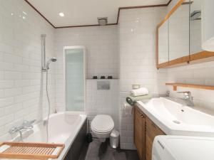 a bathroom with a tub and a toilet and a sink at Apartment Blutsyde Promenade-29 by Interhome in Mispelburg