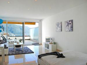 um quarto com uma cama e uma sala de estar em Apartment Residenza Solemonte by Interhome em Locarno