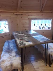 einen Holztisch in einem Zimmer mit zwei Fenstern in der Unterkunft Le Kota Montagne in Les Poulières