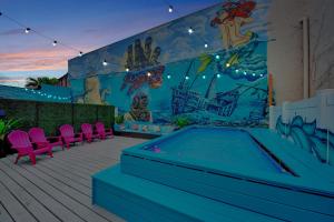 a patio with a pool and a wall with a mural at MERMAID HOUSE WITH POOL JACUZZI STEPS to SIESTA KEY BEACH in Sarasota