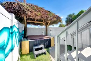 a backyard with a grill and a straw hut at MERMAID HOUSE WITH POOL JACUZZI STEPS to SIESTA KEY BEACH in Sarasota