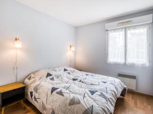ein weißes Schlafzimmer mit einem Bett und einem Fenster in der Unterkunft Apartment Tassigny by Interhome in Capbreton