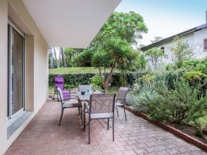 eine Terrasse mit einem Tisch und Stühlen auf einer Terrasse in der Unterkunft Apartment Tassigny by Interhome in Capbreton