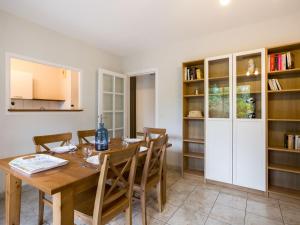 a kitchen and dining room with a wooden table and chairs at Apartment Tassigny by Interhome in Capbreton