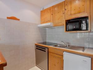 una pequeña cocina con fregadero y microondas en Apartment Le Schuss - Val Claret-5 by Interhome en Tignes