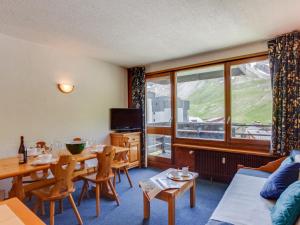 sala de estar con mesa, sillas y ventana en Apartment Le Schuss - Val Claret-5 by Interhome en Tignes